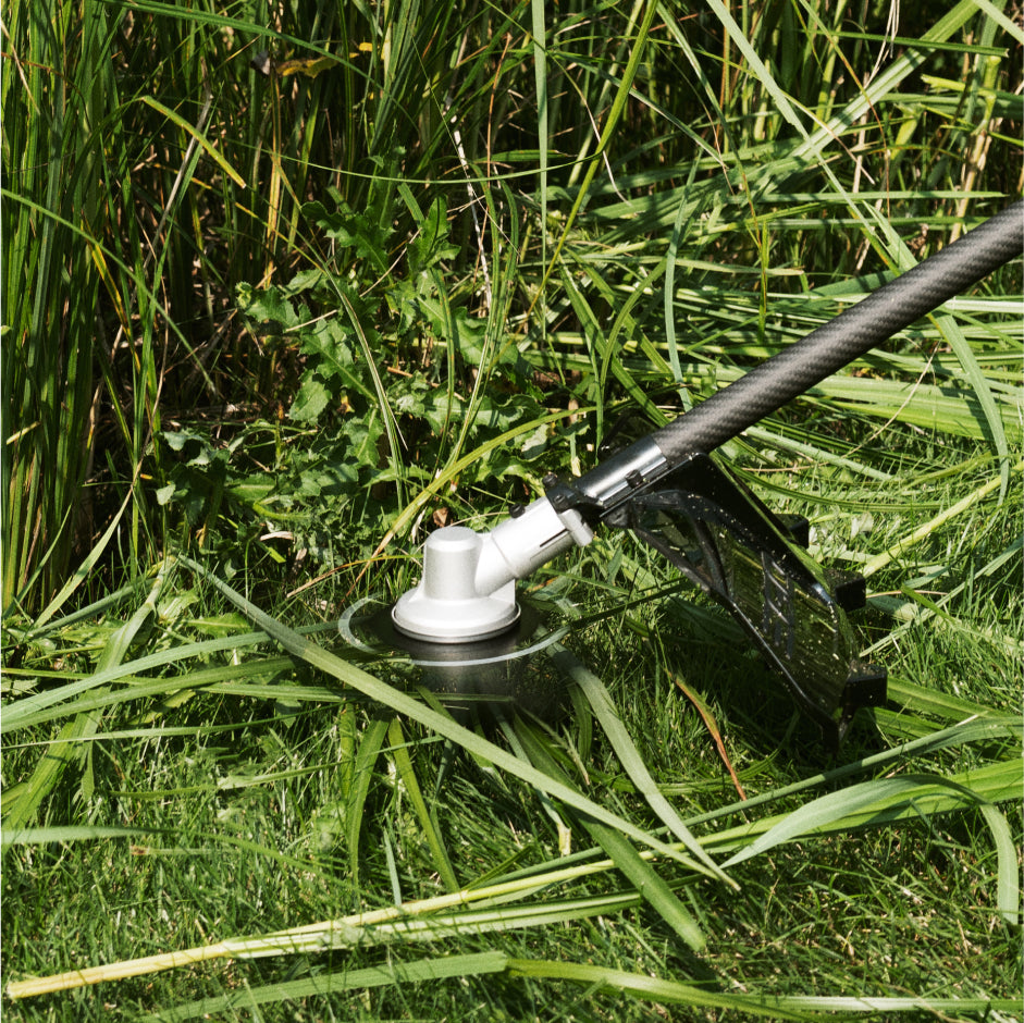 Closeup of the EGO Commercial Bike Handle Brush Cutter with carbon fiber shaft in use