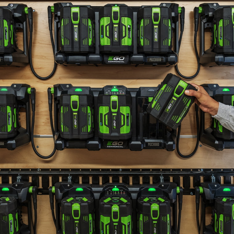 Man taking a 56V ARC Lithium battery from a row of interconnected 3-Port Docks